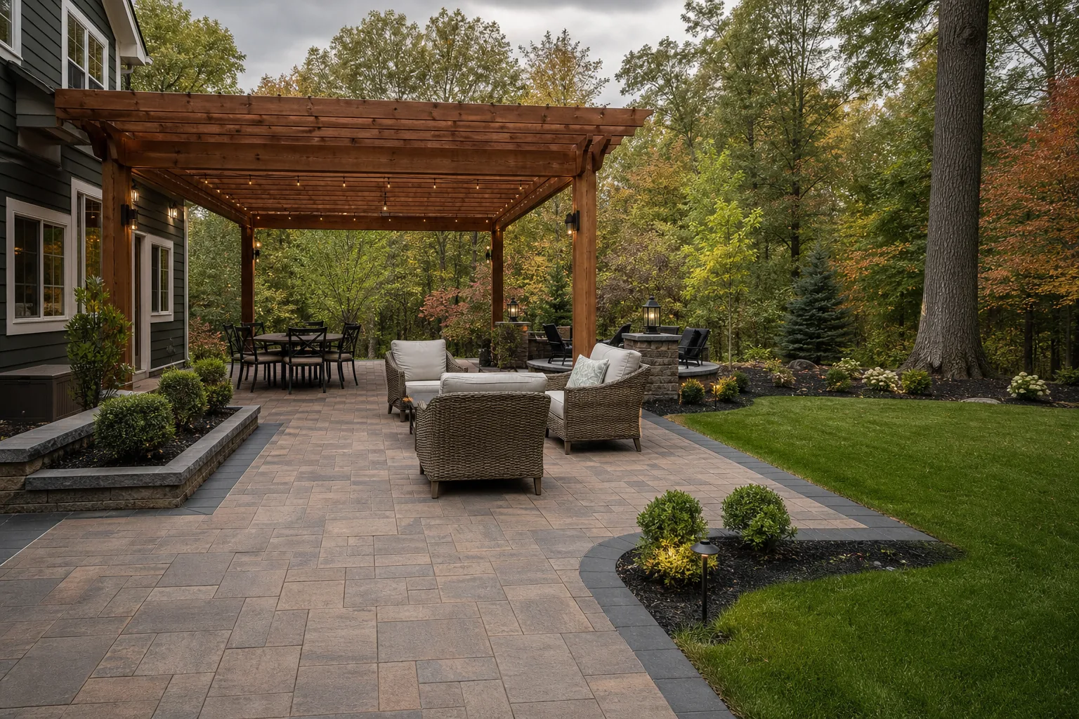 Shaded pergola over a durable paver patio in a wooded Oakland County backyard with autumn foliage